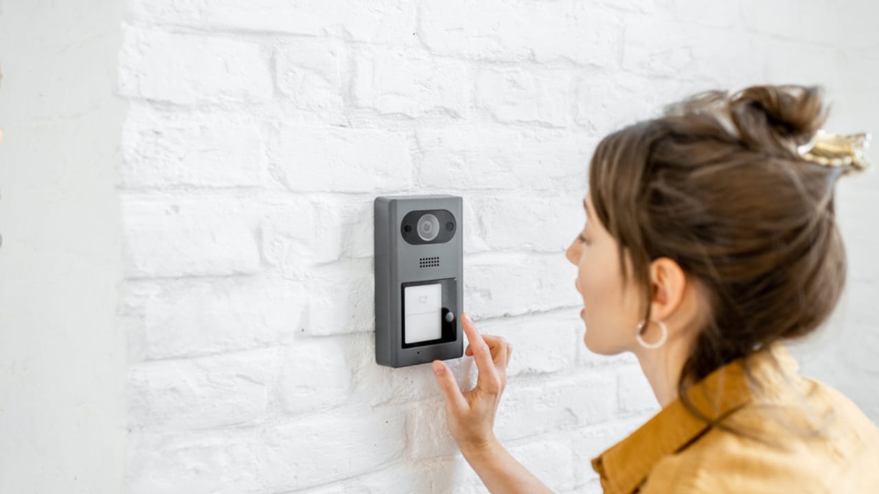 The Dark Side of Smart Doorbells: 14 Dangers You Shouldn’t Ignore 14 The Dark Side of Smart Doorbells: 14 Dangers You Shouldn’t Ignore - Woman rings the house intercom with a camera ss1747420283 dpdgm