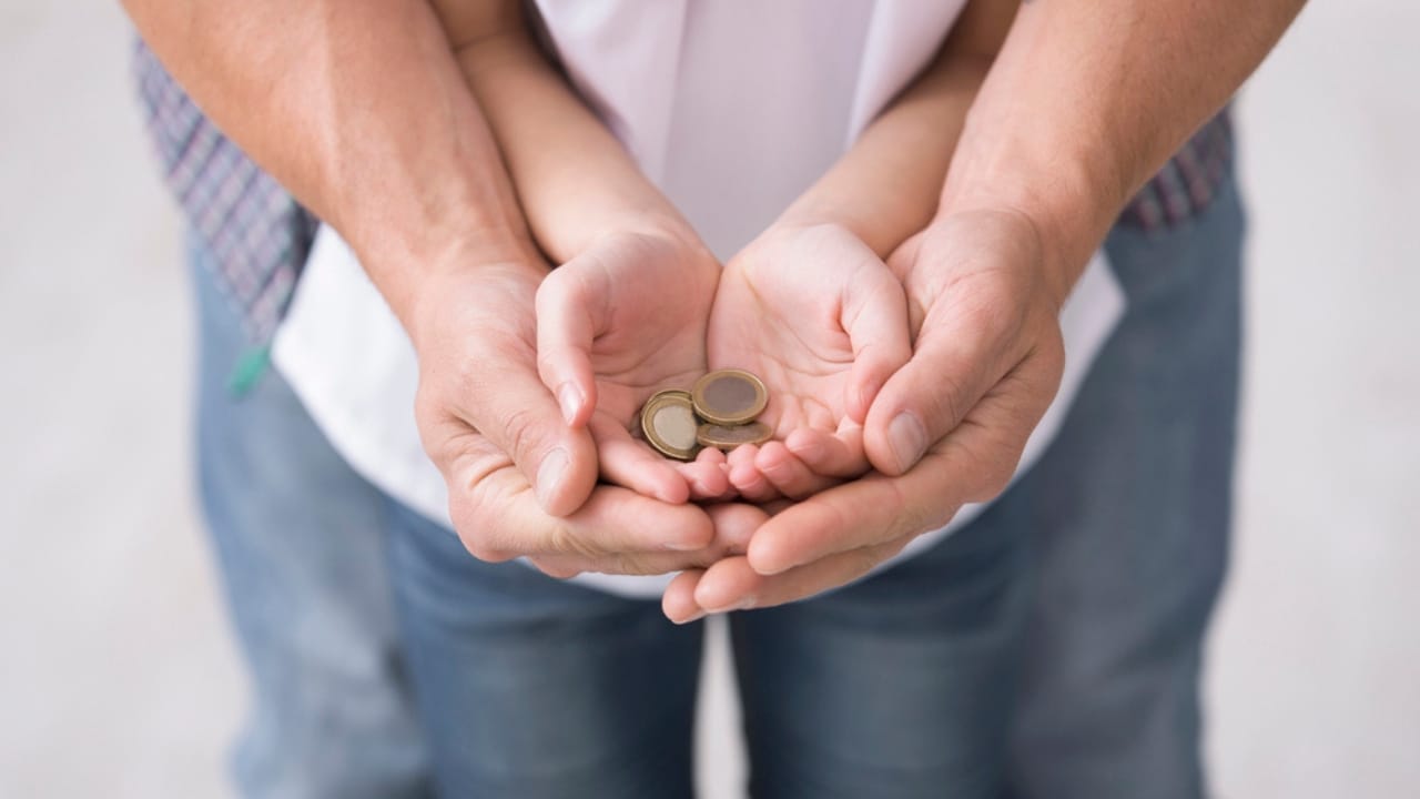 13 Amish Money-Saving Habits to Cut Your Household Costs 11 13 Amish Money-Saving Habits to Cut Your Household Costs - dad and daughter holding coins dp254096840 dnoh