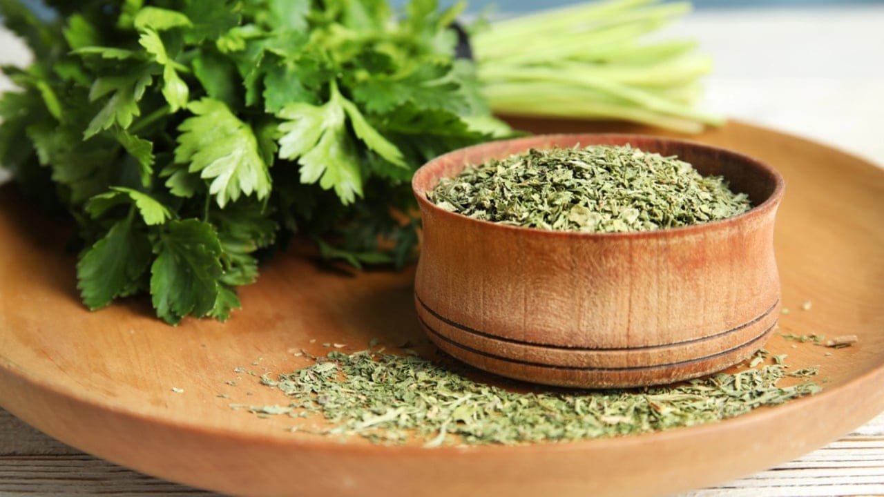11 Herbs to Dry Now for Freshness That Lasts All Year - fresh and dried parsley on table dp314778670 dnoh