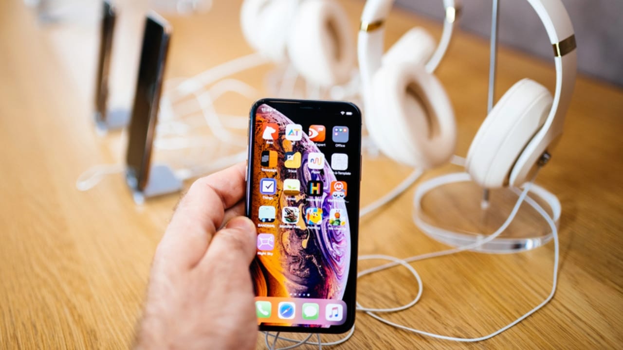 14 Everyday Luxuries Americans Are Cutting to Fight Inflation 10 14 Everyday Luxuries Americans Are Cutting to Fight Inflation - hand of man holding iPhone at store dp222288404 dnoh