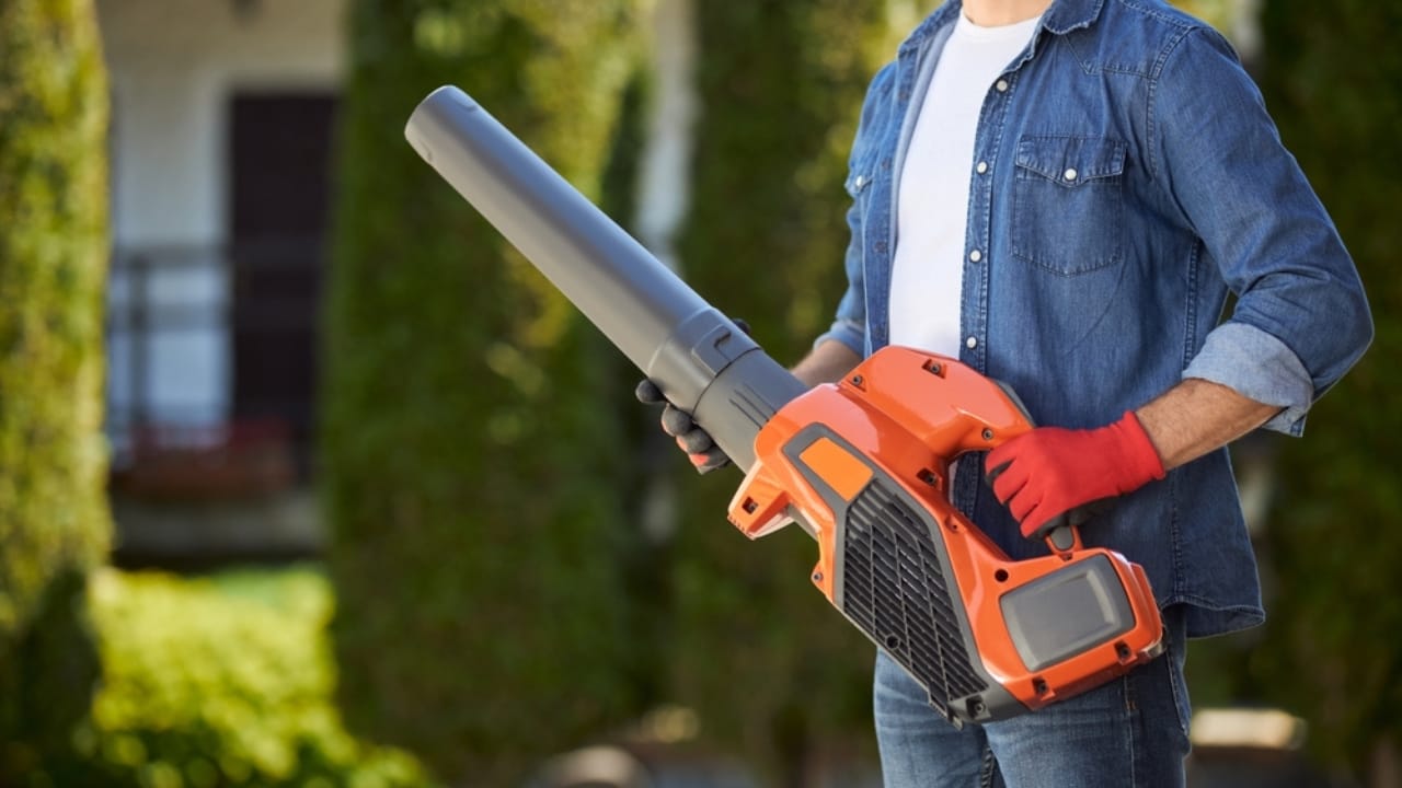 12 Leaf Blower Hacks That Will Change How You Use It Year-Round - man holding leaf blower ss2359132381 adyh