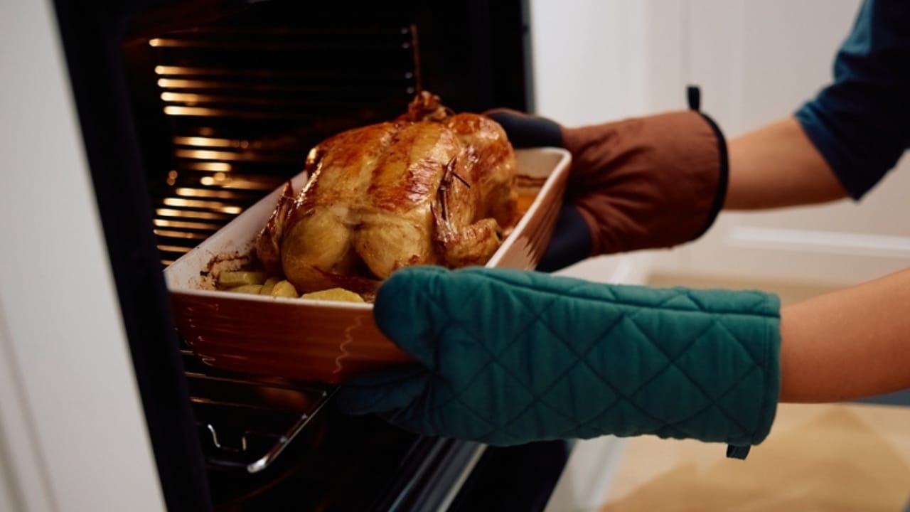 10 Steps to Perfect Roast Chicken for the Holidays 8 10 Steps to Perfect Roast Chicken for the Holidays - Close up of woman roasting chicken ss2531959829 dpdgm