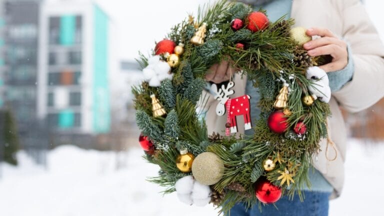 25 Unique Christmas Wreaths to Elevate Your Holiday Decor 4 25 Unique Christmas Wreaths to Elevate Your Holiday Decor - Woman Holding Christmas Wreath in Snow ss2465950539 dpdgm