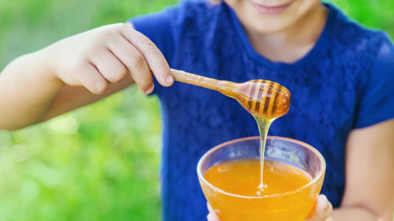Nature's Perfect Pair: The Hidden Potential of Honey and Cinnamon 9 Nature's Perfect Pair: The Hidden Potential of Honey and Cinnamon - young girl holding honey dp300096764 dnoh